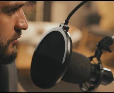 a man in a recording studio with a microphone and a microphone