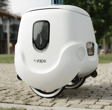 Yape, il robot di consegna autonomo italiano con espressione simpatica, mentre consegna un pacco
