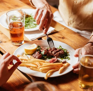 foto di un piatto di carne succulento con patatine fritte e delle birre. Scena di life style