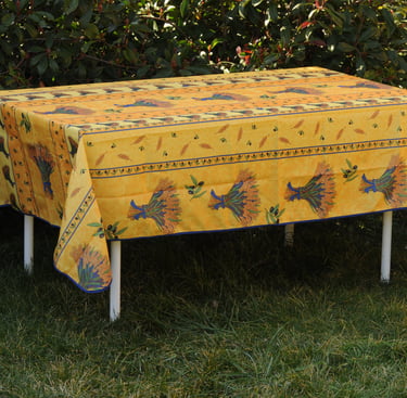 Une nappe avec une nappe provençal jaune par dessus