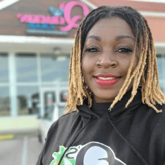 a woman in a black shirt with braided hair smiling
