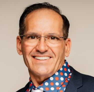 a man in a suit and tie with a polka dot shirt