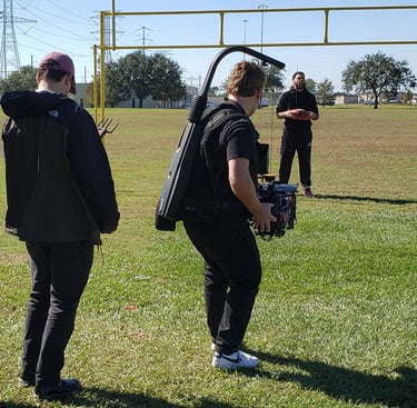 Video content production onsite on a football field with a player.