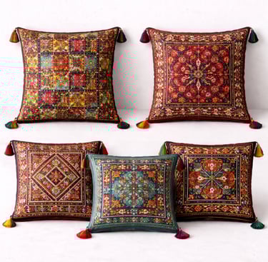 Tribal cushion covers with embroidered patterns, tassels, and ethnic motifs.
