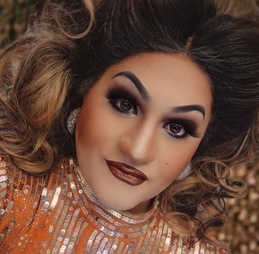 drag queen dixie surewood with gold dress and glam makeup