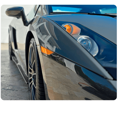 Close-up of a grey Lamborghini Gallardo luxury supercar showing headlight and alloy wheel.