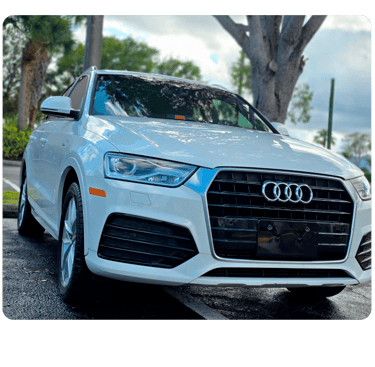 Front view of a white Audi Q3 luxury compact SUV parked outdoors on a paved surface.