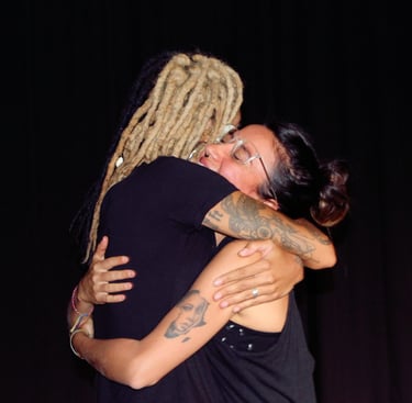 Actriz afro con rastas abraza a su compañera