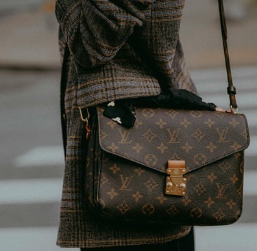 Femme lgante en tenue marron portant une sacoche Louis Vuitton - L'Atelier du Mieux