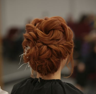 Recogido nupcial elegante en una mujer pelirroja con un moño trenzado intrincado