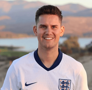 Portrait of a person wearing an England football shirt, smiling towards the camera outdoors