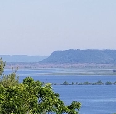 a wide river with a bluff in the background