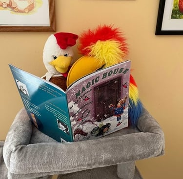 Stuffed parrot and rooster sit on a grey cat tree, appearing to read Magic House by Ina Chitenco.