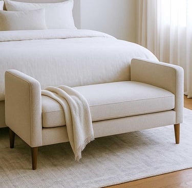 mall bench sofa at the foot of a bed in a cozy, modern bedroom with soft lighting and layered neutral textures.