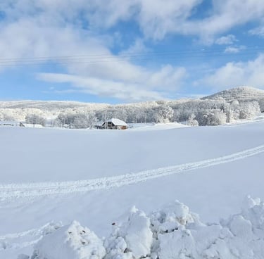 a snow covered field with a ski lift in the background