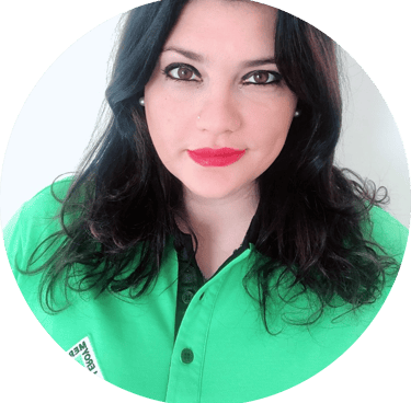 Professional portrait of a woman with dark wavy hair wearing a green polo shirt.
