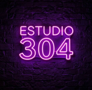 A sophisticated low-angle photograph of a premium adult modeling studio background in Latin American / Global. In the center, a glowing neon sign on a dark brick wall clearly reads ESTUDIO 304 in bright neon pink and electric purple colors. Seductive dark purple atmosphere, highly detailed, high-end adult entertainment aesthetic.