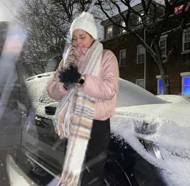 a woman in a pink coat and scarf on a snowy day