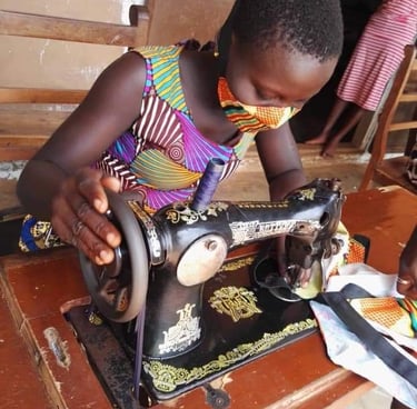 Petite fille qui fait de la couture au centre d'éducation alternatif de Zè