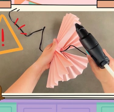 Frau klebt die Fächer mit einer Heißklebe-Pistole zusammen