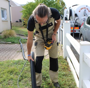 un artisan vidangeur pompant une fosse septique