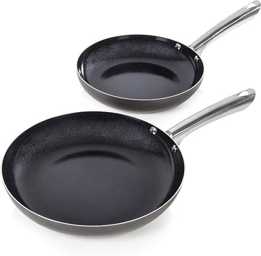 two pans with a black pan and a white background