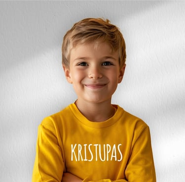 vaikas su geltonu dzemperiu ant kurio yra parasytas vardas Kristupas