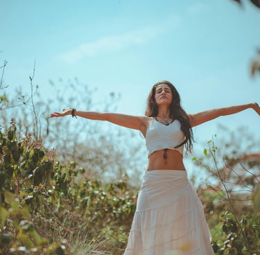 une femme en robe blanche debout dans un champ pour la Vision holistique de la Pleine Santé