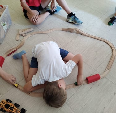 un bambino autistico gioca con un trenino di legno