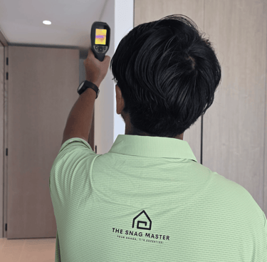 Engineer using thermal imaging camera to detect hidden moisture during property snagging inspection