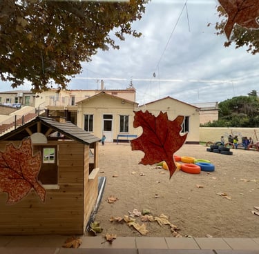 Pati de l’escola amb una caseta i fulles de tardor / Patio de la escuela con una casita y hojas de o