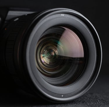 Macro shot of a high-end camera lens reflecting studio lights, sharp focus, cinematic 35mm, moody monochrome.