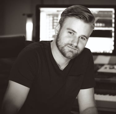 a man with a beard and a beard sitting in front of a piano. He is Ben Reno of Majestic Ape Studio.
