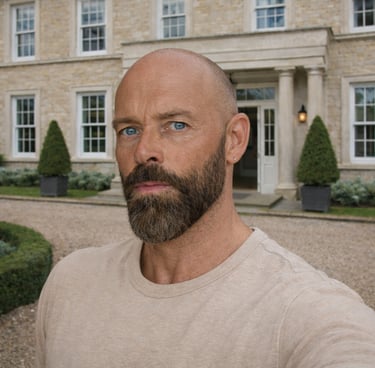 Portrait of Damon with a beard standing in front of a luxury limestone manor house.