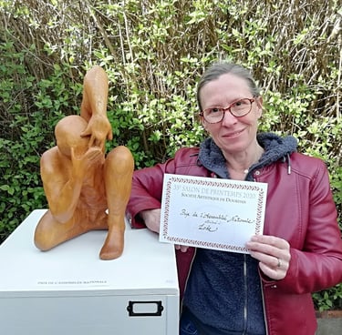 Lode posant à côté de sa sculpture Coquille, primée par l'Assemblée nationale au salon de Dourdan