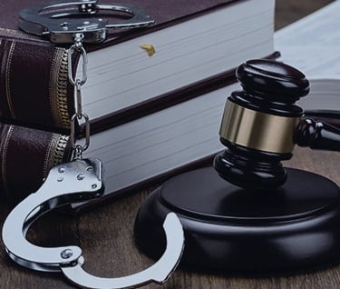 Sudski čekić, lisice i knjiga pravnih propisa , simbol kaznenog i prekršajnog prava