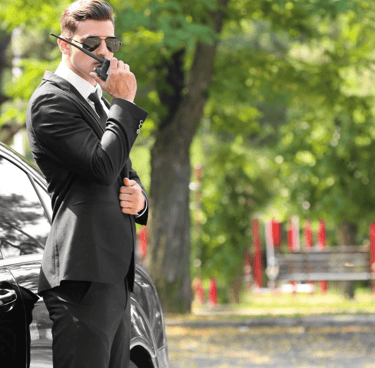 Force Prévention Sécurité – Agent de sécurité en costume noir, équipé d'une oreillette et d'un talkie-walkie, assurant la pro