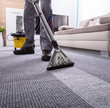 a man cleaning a carpet with a vacuum