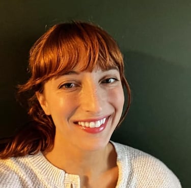 a white woman smiling at the camera in front of a green background