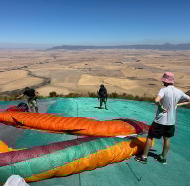 a man standing on a tarp with a paraglide
