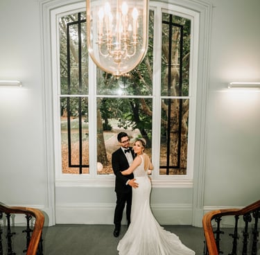 Romantic moment of a bride and groom posing on a grand staircase for their wedding photos