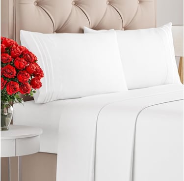 a bed with a bouquet of roses in front of a bed