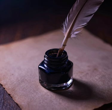 Macro close-up of an antique ink well with a delicate feather quill pen, resting on deckled-edge paper under soft candlelight, deep shadows and luminous highlights, dark moody photography.
