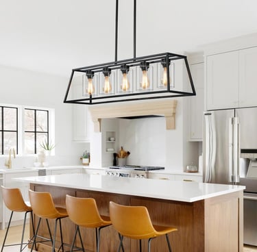 Modern black cage island chandelier with Edison bulbs hanging over a white marble kitchen island.