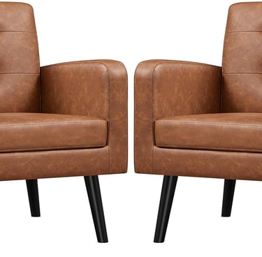 Pair of cognac brown faux leather accent chairs with tufted backrests and black tapered legs.