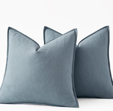 Set of three dusty blue linen decorative throw pillows with flange edges for home decor.