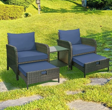 Outdoor 3-piece wicker patio set with blue cushions, two chairs, ottomans, and a side table on a sunny lawn.