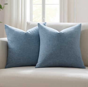 Pair of blue textured decorative throw pillows on a neutral sofa in a bright living room.