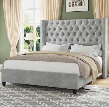 Modern grey tufted wingback bed frame with velvet upholstery in a bright bedroom.