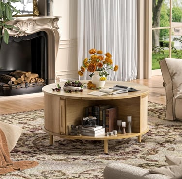 Round light wood coffee table with storage shelf in a bright living room near a fireplace.